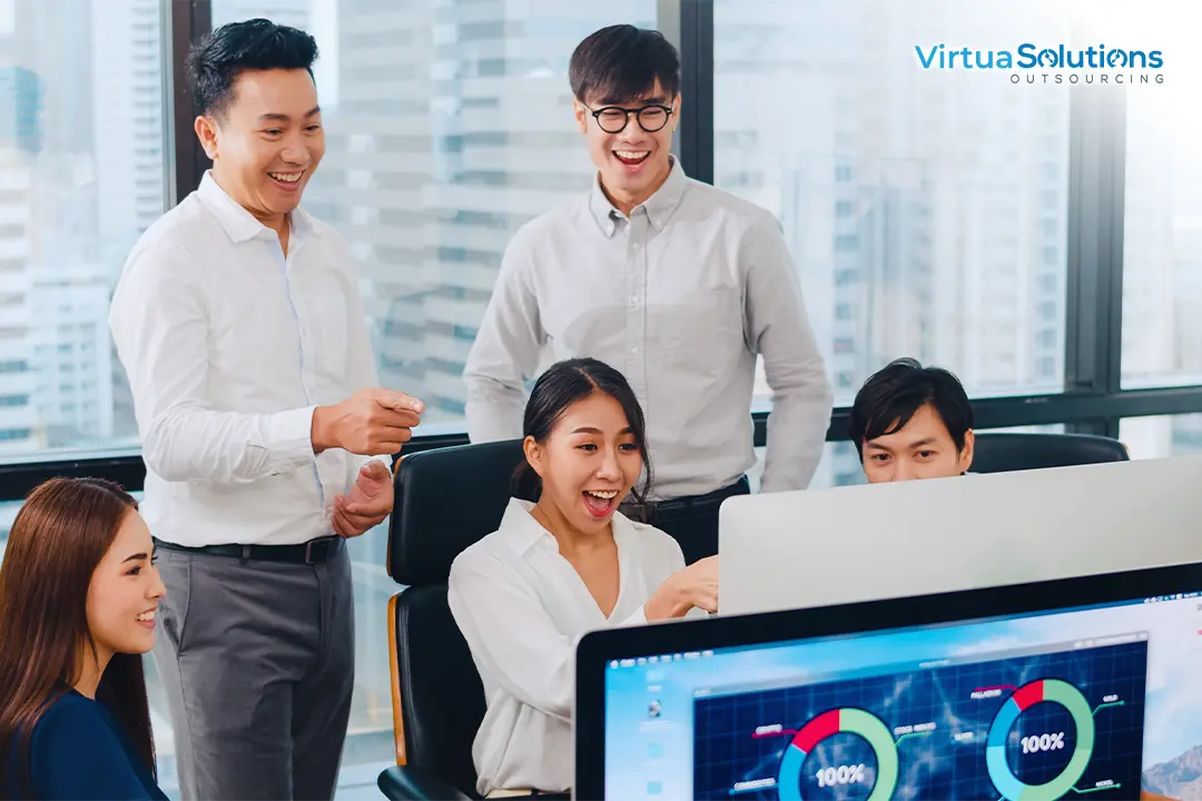 Filipino professionals working around a computer screen