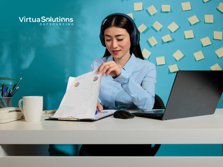 Virtua Outsourcing Solutions team member wearing a headset reviewing reports